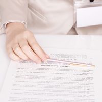 Hand holding pen on a document.