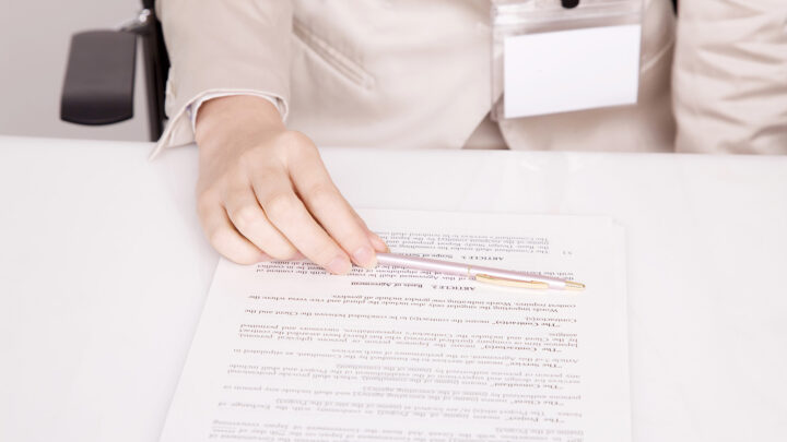 Hand holding pen on a document.