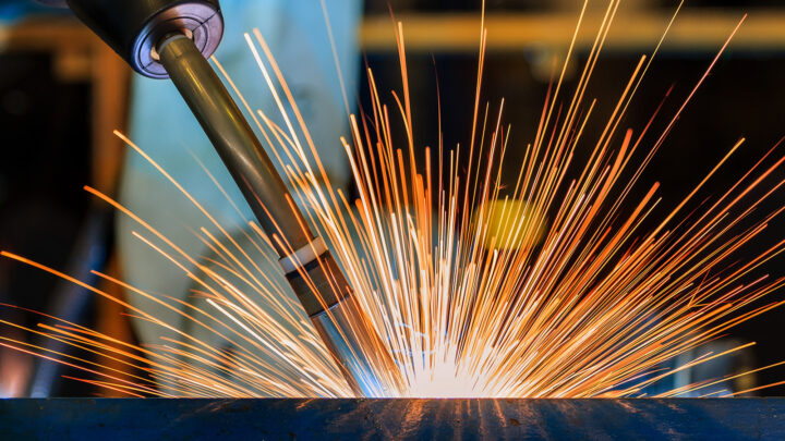 A welding tool causing orange sparks in a sunburst pattern